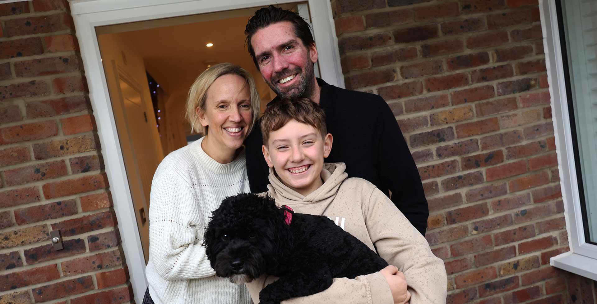 Family photo with dog in front of new house